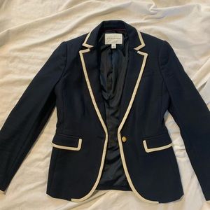 Navy blazer with cream seams and gold decorative button